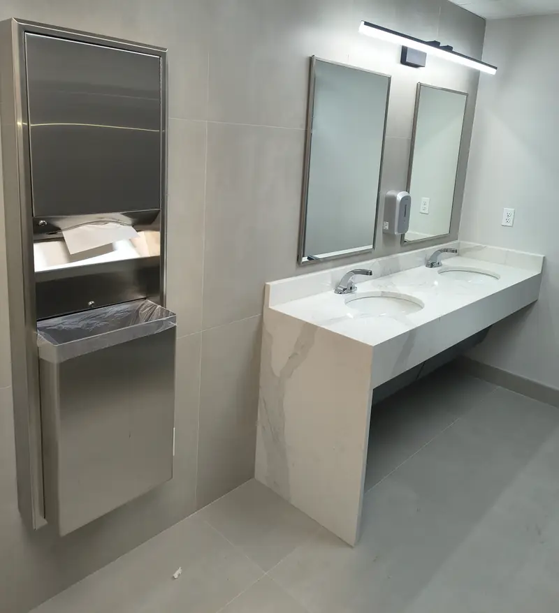 Restroom with two sinks, chrome faucets, and mirrors