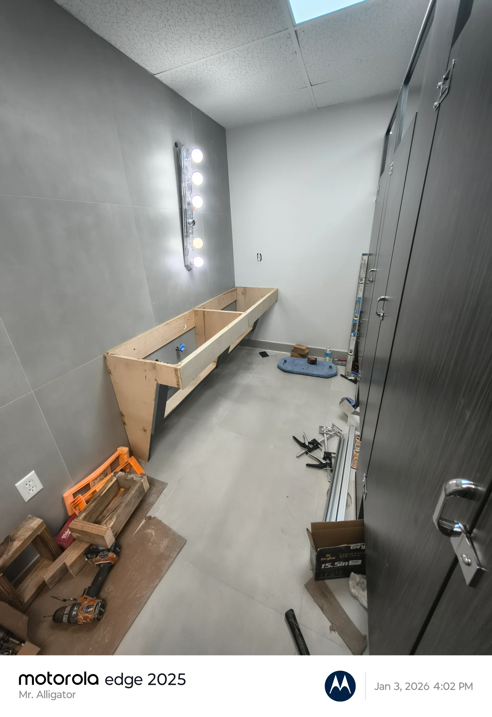 In-progress structural wood framing for a heavy-duty wall-hung commercial vanity unit with lighting trim.